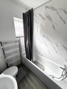 a bathroom with a white toilet and a sink at 3-Bedroom House, with free parking in Luton