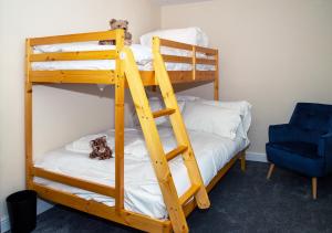 Rose Cottage, Kepwick Village with Hot Tub - Rural Location في Kepwick: سريرين بطابقين في غرفة مع كرسي أزرق