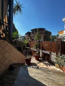 a fence with potted plants in front of a house at Villa D&C casa affitto breve in Frattaminore