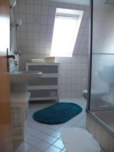 a bathroom with a sink and a toilet and a window at Ferienwohnung Luise in Carolinensiel