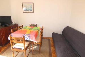 Habitación con mesa, cama, mesa y sillas. en By the sea apartment, en Pag