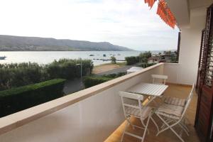Un balcón con mesa y sillas y vista al agua. en By the sea apartment, en Pag