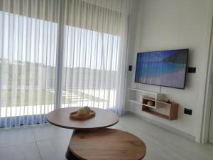 a living room with a table and a flat screen tv at Villa ENI in Draç