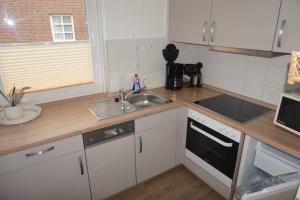 a kitchen with a sink and a counter top at Ferienhaus Fischerstraße 11 in Carolinensiel