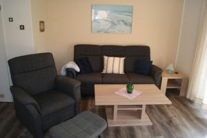 a living room with a couch and a table at Ferienhaus Fischerstraße 11 in Carolinensiel