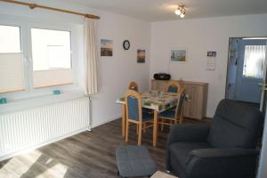 a living room with a table and a chair at Ferienhaus Fischerstraße 11 in Carolinensiel