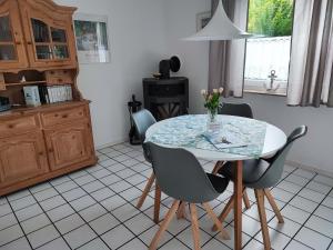 a kitchen with a table and chairs with a vase of flowers at Haus Strandkrabbe in Hooksiel