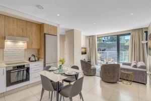 eine Küche und ein Wohnzimmer mit Tisch und Stühlen in der Unterkunft The Terrace101- 2 Bed, Sandton in Johannesburg