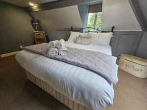 a bedroom with a large bed with towels on it at William Oakes Georgian Garden House - Bridgnorth Pass the Keys in Bridgnorth
