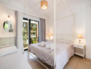 a white bedroom with a canopy bed and a window at Villaggio Maistro in Lefkada +65 photos