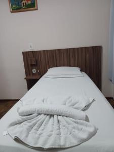 a bed with white towels on top of it at Florida Confort Hotel in União da Vitória