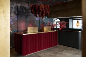 a red counter in a room with a wall at Aiola Living Boutique Hotel Graz in Graz