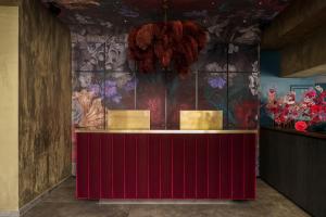 a red counter in a room with flowers on the wall at Aiola Living Boutique Hotel Graz in Graz