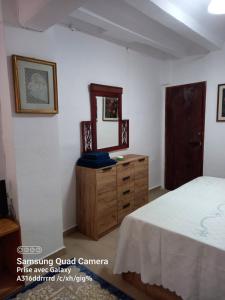 a bedroom with a bed and a dresser and a mirror at Casa De Giulio in Cocentaina