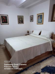 a bedroom with a large bed with white sheets at Casa De Giulio in Cocentaina