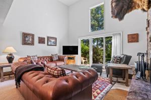 a living room with leather couches and a table at RMR: Four Seasons II 1 Condo in Teton Village in Teton Village