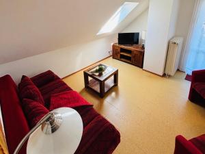 a living room with a red couch and a table at Deichgräfin 4 in Horumersiel