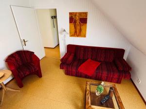 a living room with a red couch and a table at Deichgräfin 4 in Horumersiel