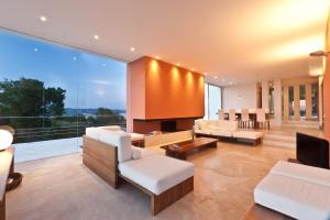 un salon avec des meubles blancs et une grande fenêtre dans l'établissement Stunning Seaside Oasis in Ibiza, 1049, à Port des Torrent