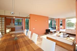 une salle à manger et un salon avec une table et des chaises dans l'établissement Stunning Seaside Oasis in Ibiza, 1049, à Port des Torrent