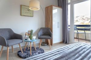 2 stoelen en een tafel in een kamer met een raam bij Lister Duenennest in List