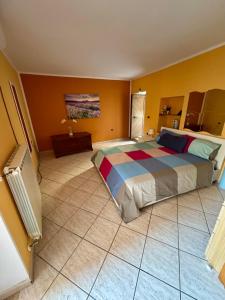 a bedroom with a large bed and a tile floor at Bella casa nel cuore del Cilento in Montano Antilia