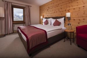 a bedroom with a large bed with a wooden wall at Riffelhaus 1853 in Zermatt