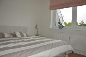 a white bedroom with a bed and a window at Schönes Wohnen am Nordseestrand in Wyk auf Föhr +280 photos