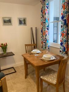 een eetkamer met een houten tafel en stoelen bij Ludford View, riverside cottage in Ludlow with private parking in Ludlow