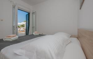 a bedroom with a white bed with a view of the ocean at Villa Mandina - Makarska by Villas Guide in Makarska +20 photos