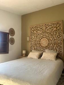 a bedroom with a bed with a large headboard at Finca Los Arcos Bed and Breakfast Comares Malaga in Comares