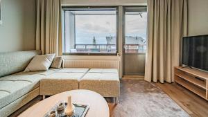 a living room with a couch and a large window at Ylläs Chalets 4101 in Ylläsjärvi