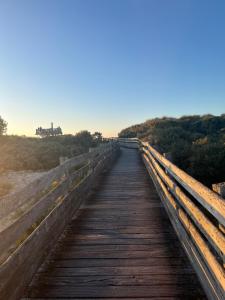 a wooden bridge over a field with a building in the distance at La marée in Étaples