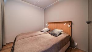 a bedroom with a large bed with a wooden headboard at Ylläs Chalets 4101 in Ylläsjärvi