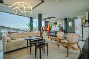 ein Wohnzimmer mit einer Couch und einem Tisch und Stühlen in der Unterkunft Trypiti Resort Blue Dream Palace and Hive Water Park in Limenaria + 37 Fotos