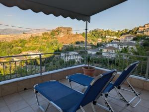 2 sillas azules en un balcón con vistas en Inn Cloud Gjirokaster, en Gjirokastra