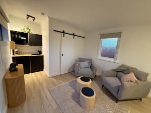 a living room with a couch and a chair at Mont-Eggo Boutique Garden Studio in New Town