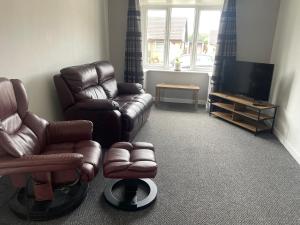 a living room with a couch and a chair and a television at Cosy bungalow Branton Doncaster near Yorkshire wildlife park and doncaster centre in Cantley