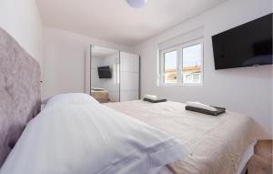 a white bedroom with a bed and a flat screen tv at Cozy Apartment In Vir With Wifi in Vir
