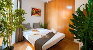 Un dormitorio con una cama con plantas. en High-End Luxury Flat with FREE Parking - Malaga Beach, en Málaga