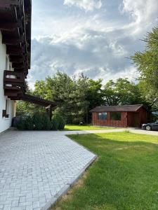 a house with a brick driveway and a building at Casa Tirol Campulung in Câmpulung +30 photos