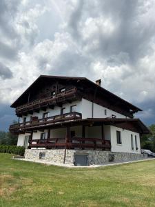 a large white building with a roof at Casa Tirol Campulung in Cîmpulung +30 photos