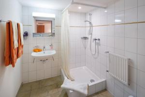 Un baño blanco con ducha y lavabo. en Seemöwe Swiss Quality Hotel, en Güttingen 53 fotos más