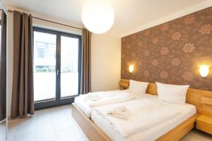 ein Schlafzimmer mit zwei Betten und einem großen Fenster in der Unterkunft Villa Baltic Sun in Ostseebad Sellin