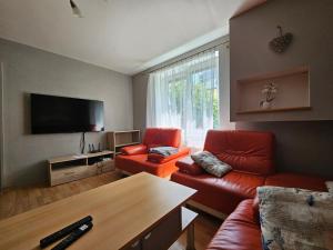 a living room with red furniture and a flat screen tv at Apartmán u Martina in Poprad