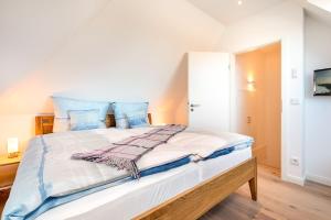 Un dormitorio con una cama grande con almohadas azules. en Wildrose, en Zingst