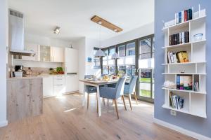 Una cocina y un comedor con mesa y sillas. en Wildrose, en Zingst