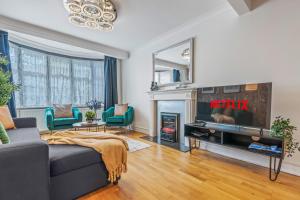 a living room with a couch and a fireplace at 6 Bedroom Perivale Haven - Pool Table - Parking in Perivale