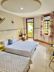 a bedroom with two beds and a large window at Khách sạn THIÊN lý in Liên Trì (4)