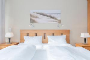 ein Schlafzimmer mit 2 weißen Betten und einem Gemälde an der Wand in der Unterkunft Seepark Sellin FeWo AG Whg 314 in Ostseebad Sellin